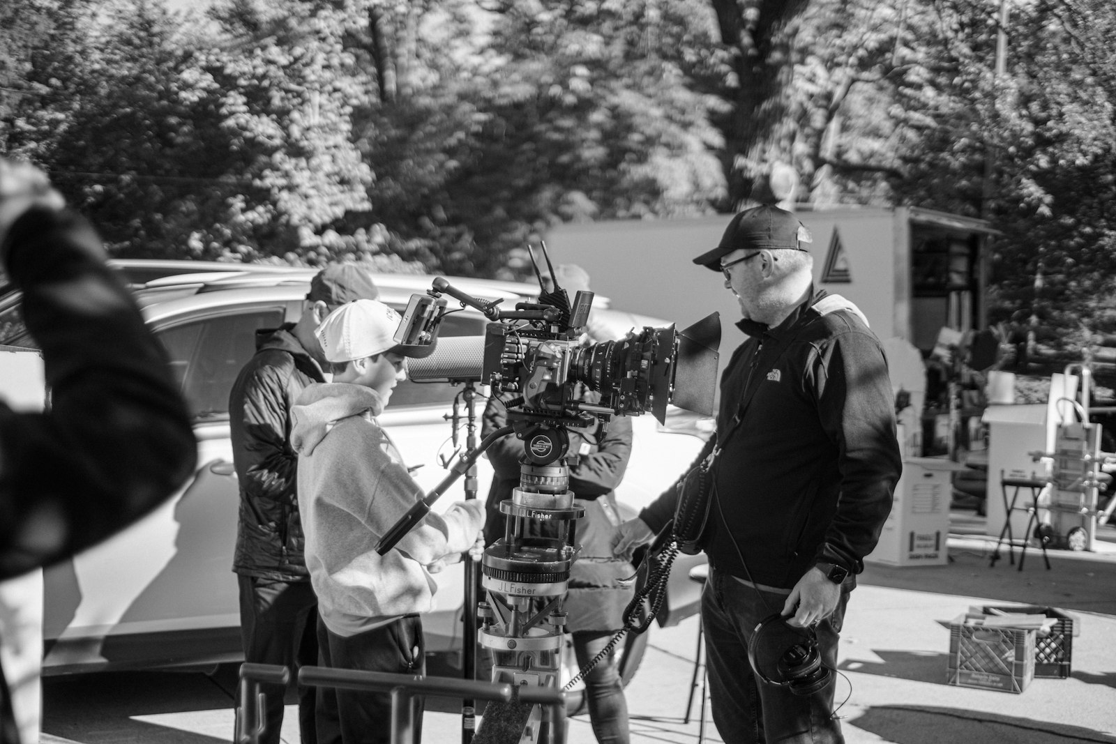 Black and white photograph of a film crew gathered around a cinema camera on set